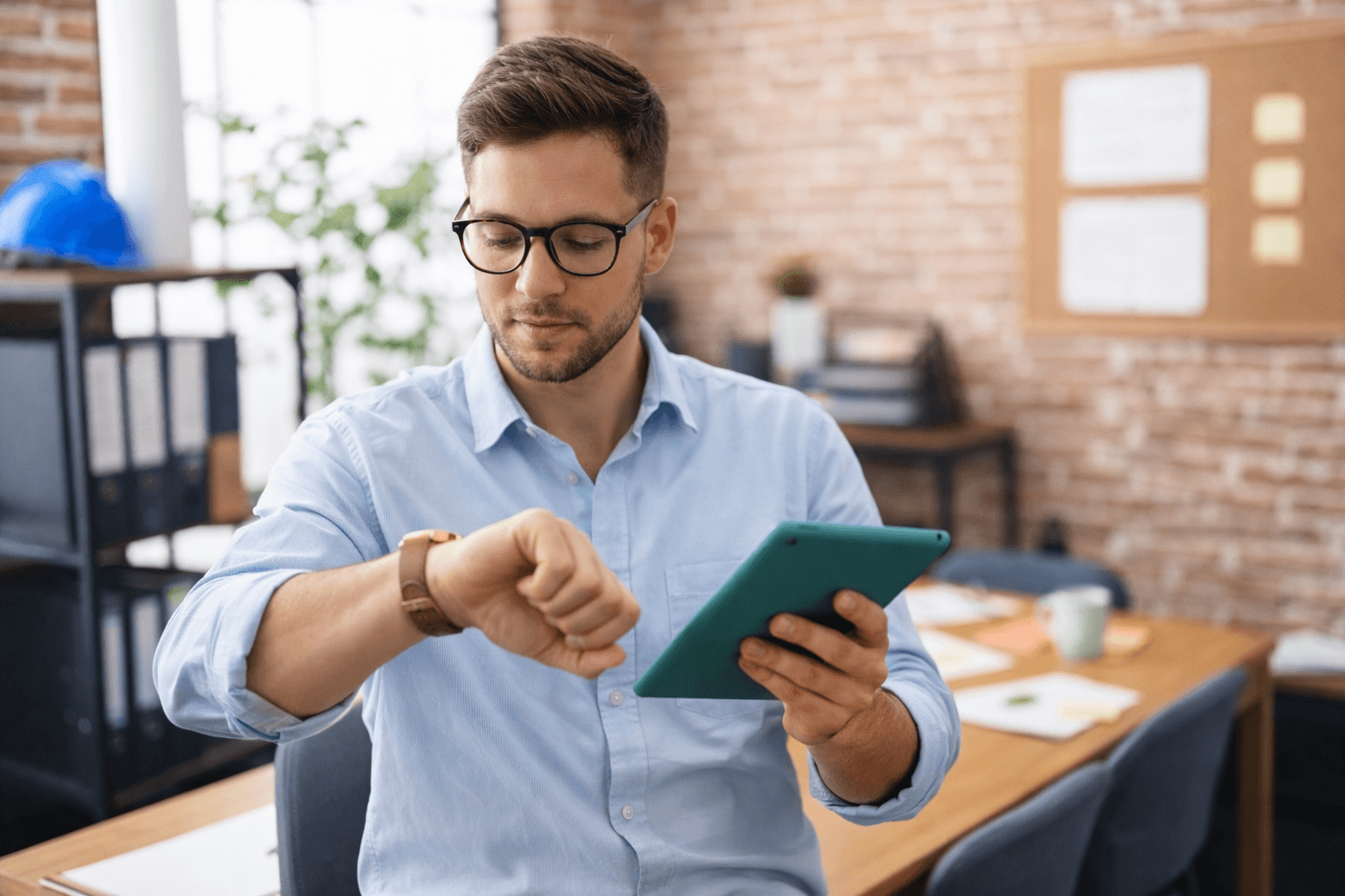 Mitarbeiter erfasst Arbeitszeit auf Tablet im Büro