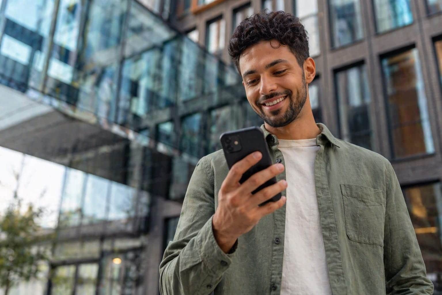 Employee in front of a modern building checking the schedule on their smartphone